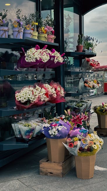 A display of fresh floral arrangements at floristtulsehill.co.uk, featuring vibrant bouquets of white, pink, and purple flowers arranged in paper wraps and vases. The bouquets include chrysanthemums, 